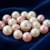 Loose natural Bahraini pearls with warm cream luster displayed on dark velvet for investment evaluation