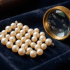 Close-up of natural Bahraini pearls being graded by luster, size and surface quality on a dark velvet board