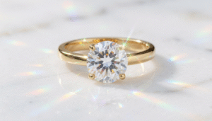 Elegant diamond solitaire ring in Bahrain set in gold displayed on white marble with soft jewelry lighting