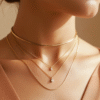 Layered gold necklace styling on Bahraini woman showing multiple chain lengths