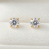 Elegant diamond stud earrings for women displayed on a white velvet jewelry stand in Bahrain
