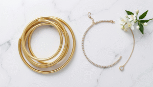 Bangle vs chain bracelet comparison on a white marble surface showing gold stacked bangles beside a diamond tennis bracelet