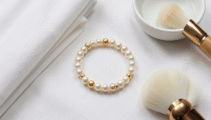 Gold and pearl bracelet on a soft white cloth with cleaning tools and a jewelry box in the background
