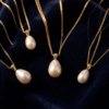 Gold pendant necklace featuring Bahraini cultural symbols including palm tree and pearl motifs